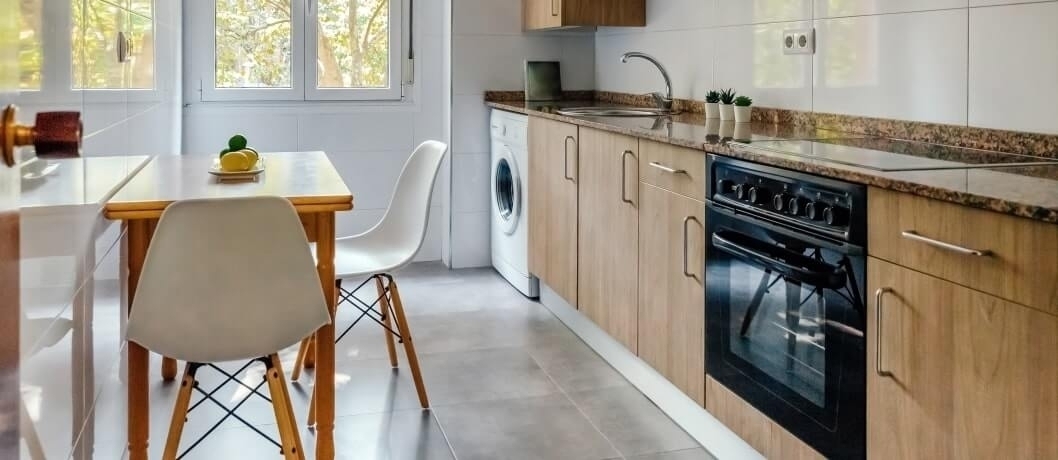 Bright modern kitchen with dining area, wood cabinets, and appliances.