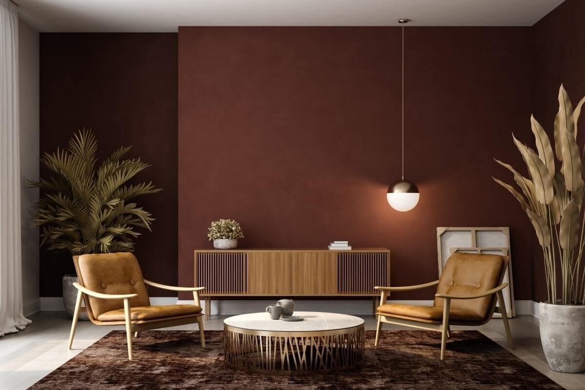 Stylish mid-century living room with burgundy accent wall, leather chairs, and wood furniture.